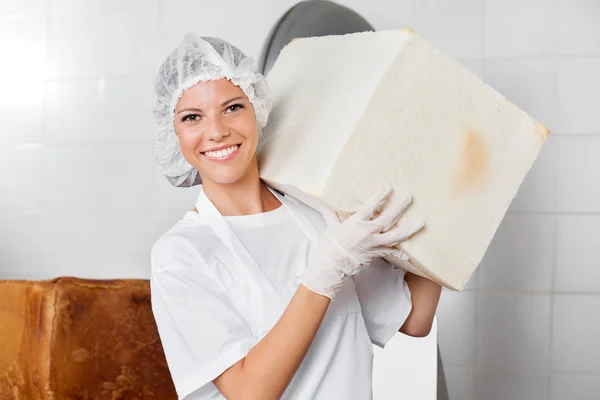 Fiducioso panettiere femminile che trasporta pane grande — Foto Stock