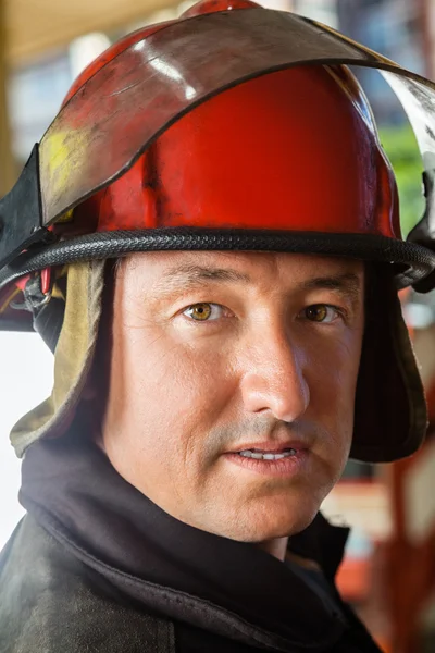 Selbstbewusster Feuerwehrmann mit rotem Helm — Stockfoto