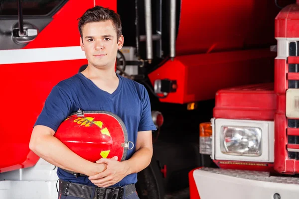 Fiducioso maschio pompiere tenendo Casco Rosso — Foto Stock