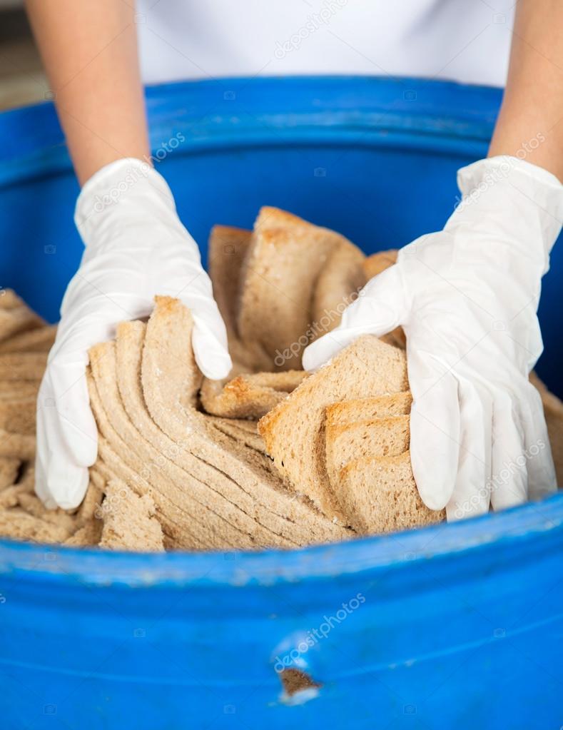Womans Hands Discarding Bread Waste In Garbage Bin