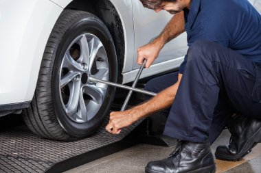 Otomobil lastiği düzeltmek için RIM anahtarı kullanarak makinist