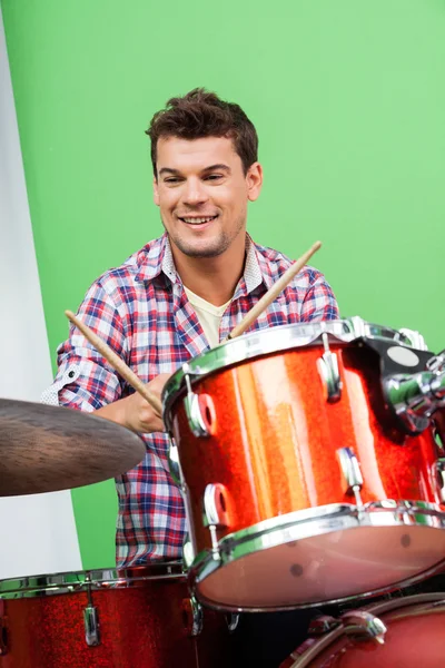 Sonriente joven tocando la batería —  Fotos de Stock