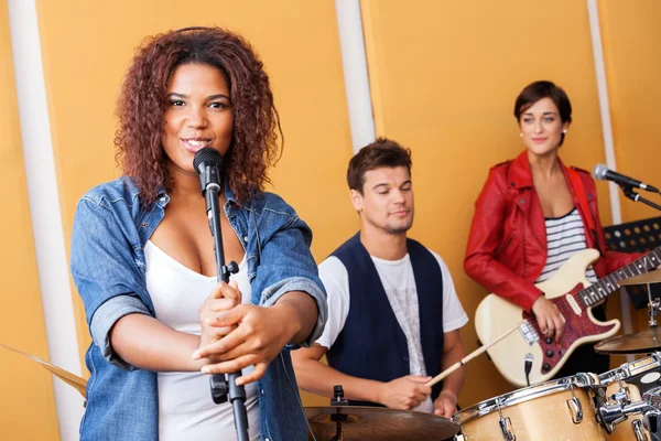 Retrato do cantor realizando com banda no estúdio de gravação — Fotografia de Stock