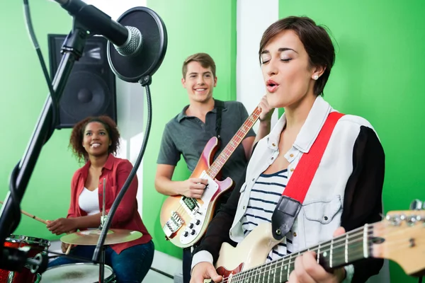 Frau singt, während Band Musikinstrument spielt — Stockfoto