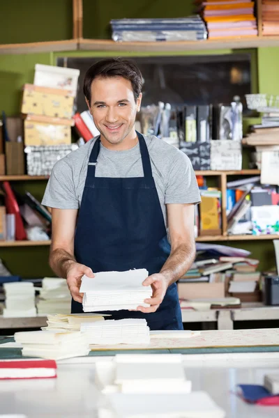 Jistý muž pracovník drží papíry na stůl — Stock fotografie