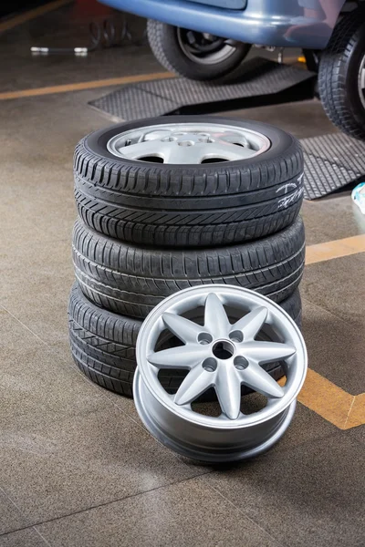 Neumáticos y tapacubos en taller de reparación de automóviles —  Fotos de Stock