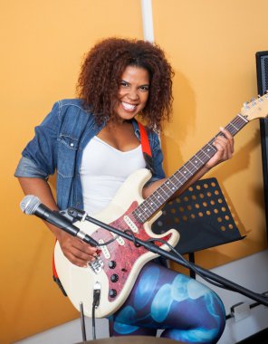 Heyecanlı erkek kayıt stüdyosunda gitar çalmak