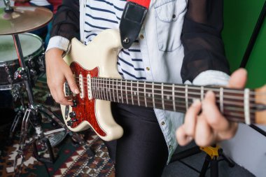 Midsection kadın gitarist gerçekleştirme