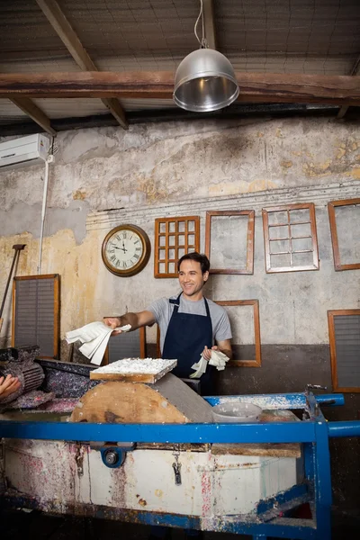 Travailleur heureux donnant des bandes de papier dans l'usine — Photo