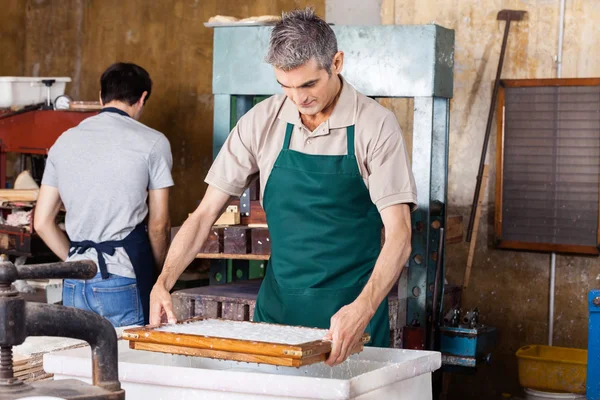 Arbeiter taucht in Papierfabrik Schimmel in pulpiges Wasser — Stockfoto