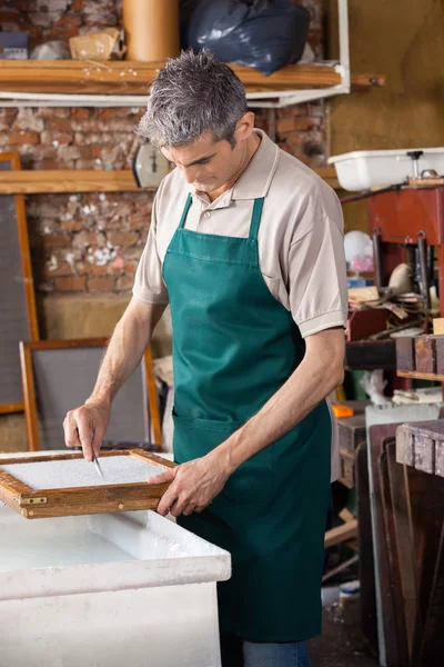 Arbetaren städning papper med pincett i fabrik — Stockfoto