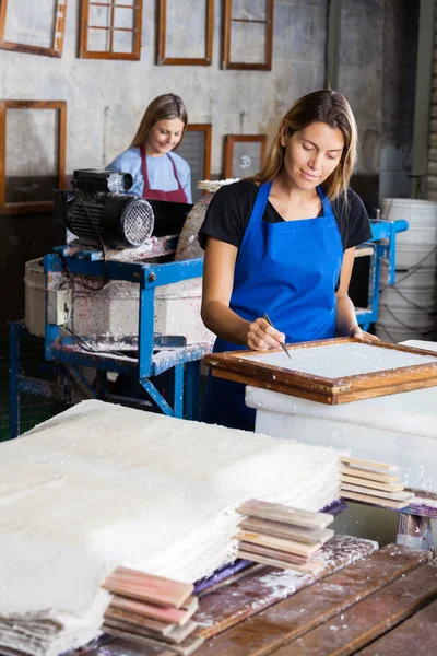 Lavoratrice che utilizza pinzette per pulire la carta sulla muffa — Foto Stock