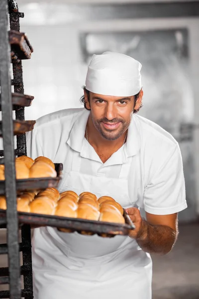 Mužské Baker odstranění pekáč z regálu — Stock fotografie