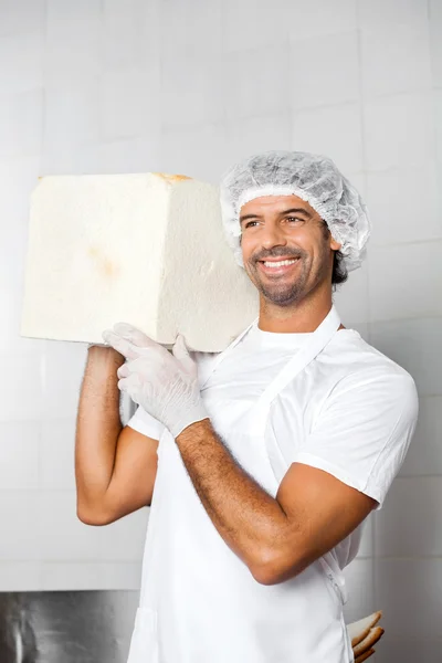 Mitten av vuxna Baker transporterar stora brödlimpa på axel — Stockfoto