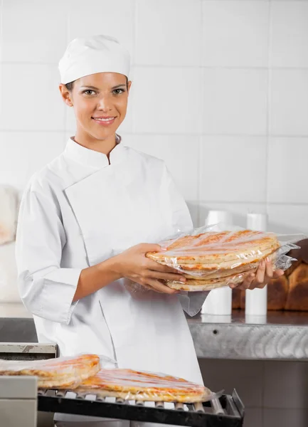 Uśmiechający się Baker gospodarstwa zapakowane pieczywo Pizza — Zdjęcie stockowe