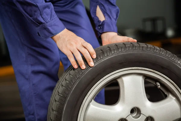 Mekaniker håller däcket i garaget — Stockfoto