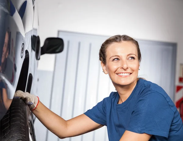 Ευτυχισμένη γυναίκα μηχανικός για τον καθορισμό των ελαστικών αυτοκινήτων — Φωτογραφία Αρχείου