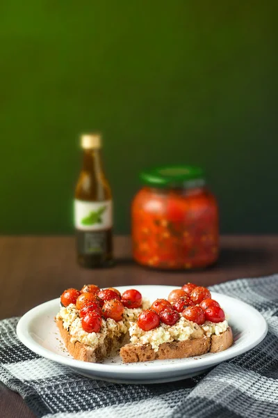 Crostini de tomate cereza y queso de cabra servido con pimienta tradicional balcánica y aceite de oliva infundido de albahaca (enfoque selectivo) ) — Foto de Stock