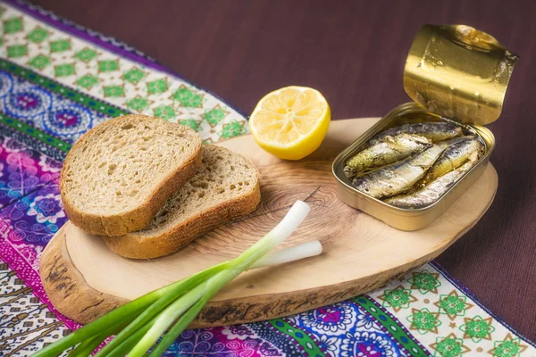 Una lata de sardinas servida con pan integral, cebolla y limón (enfoque selectivo ) — Foto de Stock