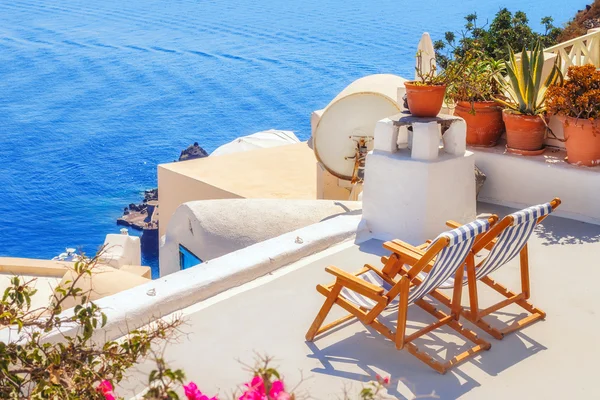 Sedie a sdraio con vista sulla caldera, villaggio di Oia, Santorini, Grecia — Foto Stock