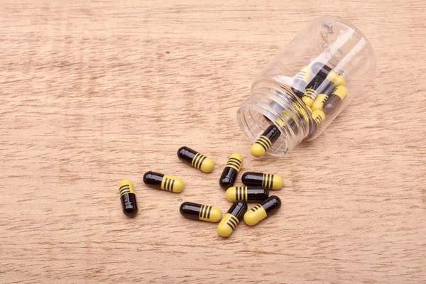 Capsules ou pilules de médicaments provenant d'une bouteille transparente — Photo