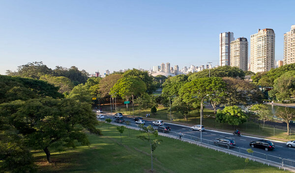 Cars traffic avenue in Sao Paulo city  near to Ibirapuera Park, a very wooded region with a lot of nature preservation.