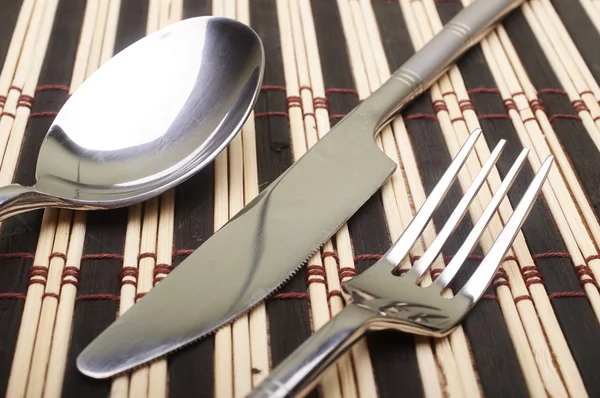 Cutlery on placemats — Stock Photo, Image