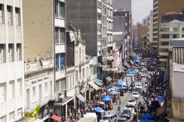 İnsanlar yürüyüş sokak 25 Mart, şehir Sao Paulo, Brezilya.