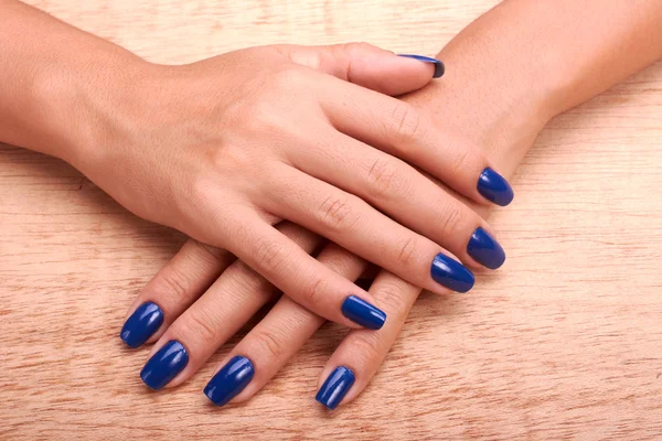 Mãos de mulher com manicure azul e esmalte — Fotografia de Stock