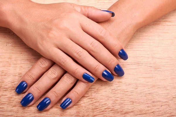 Mains femme avec manucure bleue et vernis à ongles — Photo