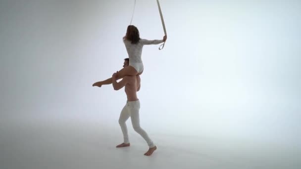 Aerial straps duo wearing white costume on white background doing performance — Stock Video