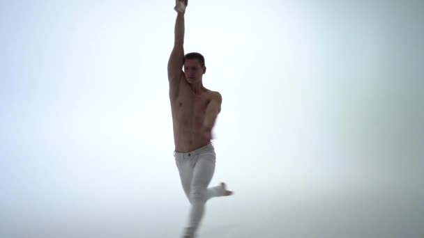 Male aerial straps artist doing performance on white background in slow motion. Concept of concentration, consciousness and motion — Stock Video