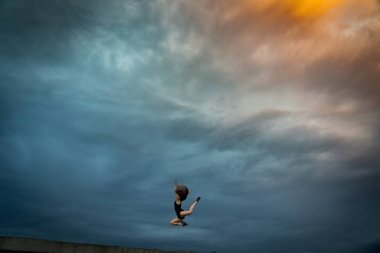 Arka planda zıplayan süper esnek bir kadın. Sağlıklı yaşam tarzı, yetenek ve arzu kavramı