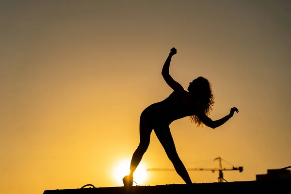 Bailarina en el borde de la azotea bailando go-go en el fondo del cielo. Concepto de estilo de vida saludable, talento y aspiración — Foto de Stock