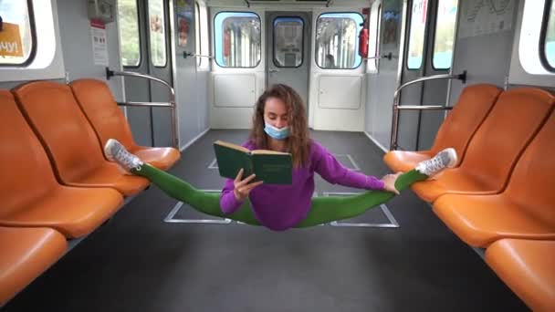 Esnek bir kadın metroda oturmuş kitap okuyor. COVID ve karantina süresince eğitim ve öz gelişim kavramı — Stok video