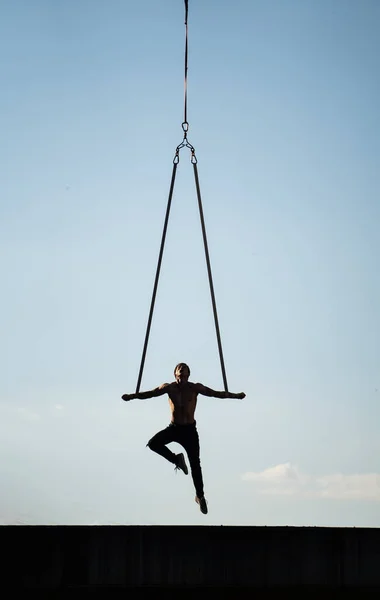 Hombre haciendo ejercicio al aire libre sobre fondo de cielo azul. Concepto calisténico, entrenamiento y estilo de vida saludable — Foto de Stock