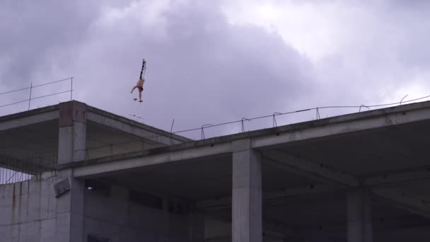 Stark cirkus Artist hålla balansen med ena handen på kanten av taket mot fantastiska molnlandskap. Risk, mod och passion — Stockvideo
