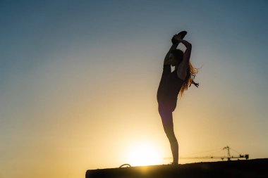  Arka planda çatıda bir kadın dansçı var. Sağlıklı yaşam tarzı, yetenek ve arzu kavramı