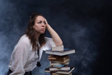 Sınav için bir sürü kitabı olan üzgün kız öğrenci. Ev eğitimini kabul et.
