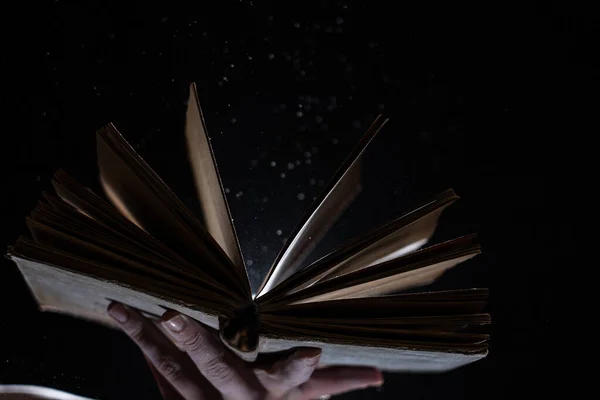 Vintage open Book Glows In The Darkness. Concept of self-education, knowledge and intellect