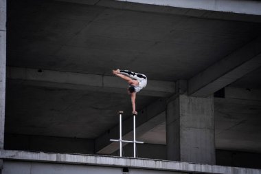 İnsan bir elinde beton yapı arka planında dengesini koruyor. Yoga, meditasyon ve sağlıklı yaşam tarzı kavramı