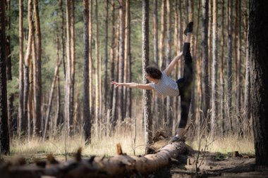Esnek kadın jimnastikçi ormanda egzersiz yapıyor. Sağlıklı yaşam tarzı 