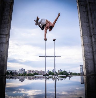 İnsanoğlu bir elinde gökyüzünde, şehir manzarasında ve bulutlu gökyüzünde dengesini koruyor. Yoga, rahatlama ve enerji kavramı