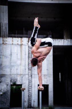İnsan bir elinde beton yapı arka planında dengesini koruyor. Yoga, meditasyon ve sağlıklı yaşam tarzı kavramı