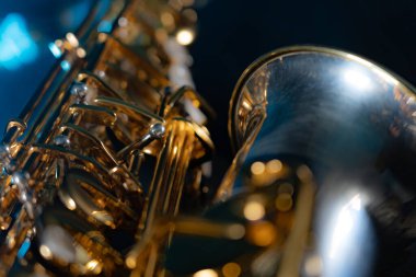 Siyah arkaplanda mavi dumanlı altın parlak alto saksafon