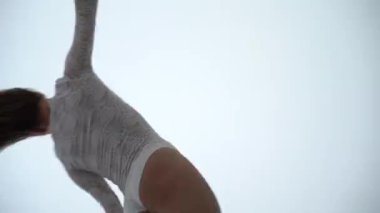 Beyaz arka planda performans sergileyen kadın hava kayışları sanatçısı. Arzu kavramı. zarafet ve dürtü 