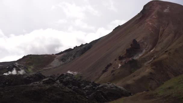 Landmannalaugar Montanhas coloridas na trilha de caminhadas Laugavegur. Islândia. A combinação de camadas de rochas multicoloridas, minerais, grama e musgo — Vídeo de Stock