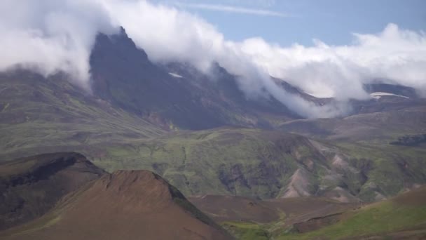 Moln som går genom bergstoppar omgivna av vulkaniska landskap. Islands natur — Stockvideo
