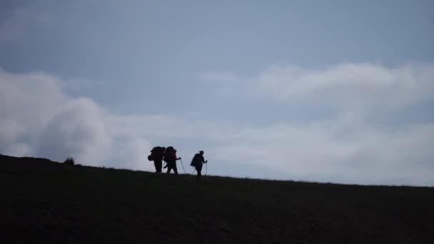 Arka planda sırt çantalarıyla yürüyen insanların siluetleri — Stok video