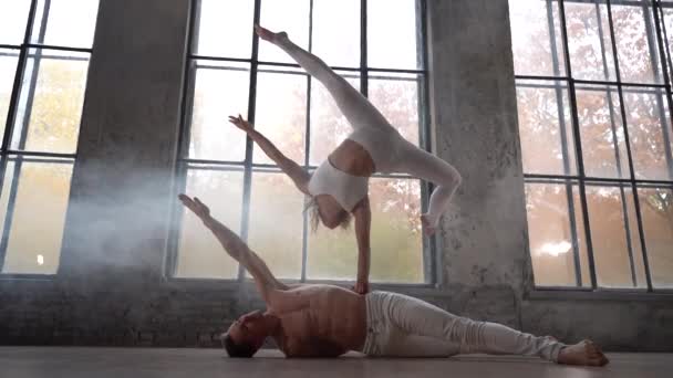 Akrobatik-Duo posiert auf dem riesigen Fensterhintergrund mit herbstlichen Orangenbäumen draußen. Konzept Beziehung, Glück und Vertrauen — Stockvideo